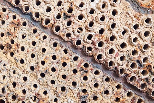 Mineral scale deposits on industrial surface in mining process water system.